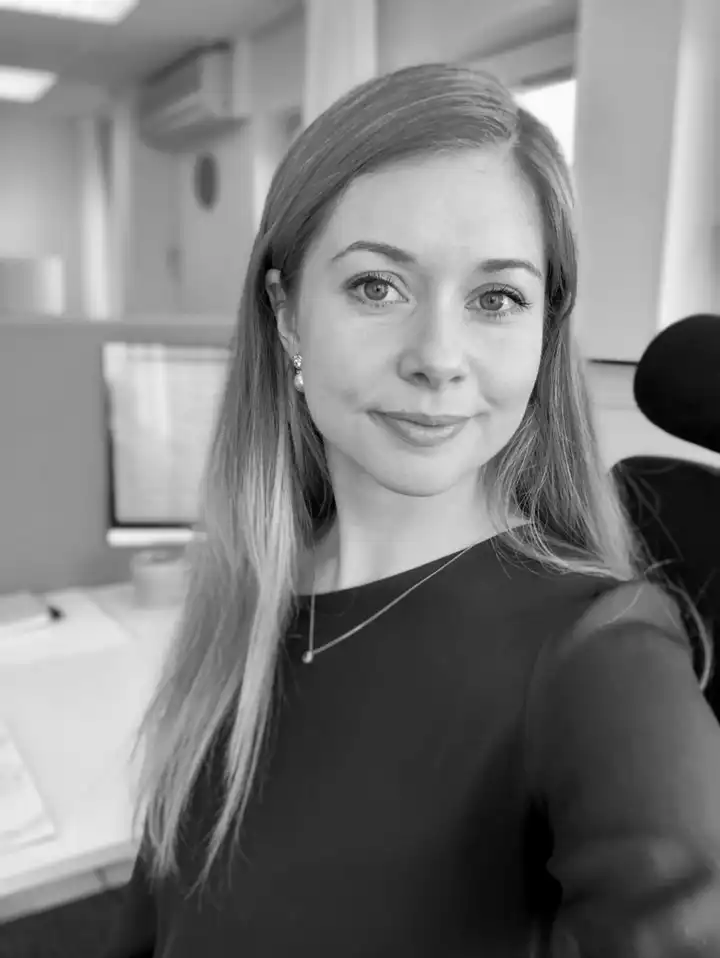 Svartvitt porträtt av Sara Plesnar Dennås i kontorsmiljö.